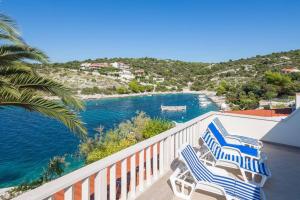 een balkon met blauwe en witte stoelen en de oceaan bij Apartments Bose Kanica on the sea in Sevid