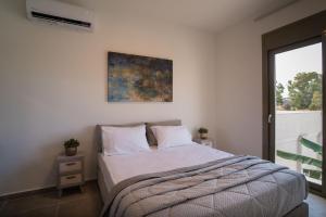 a bedroom with a bed with a painting on the wall at Lodge Apartments in Zakynthos