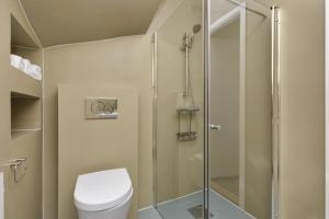La salle de bains est pourvue de toilettes et d'une douche en verre. dans l'établissement Central Studio Apartment Apt 102, à Stavanger
