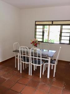 een eetkamer met een tafel en witte stoelen bij chácara legal in Socorro