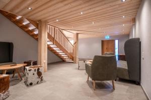 Habitación con escalera, sillas y cama en Naturhaus am Arlberg, en Warth am Arlberg