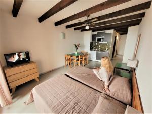 a woman sitting on a bed in a bedroom at Le California Motel in Sagone