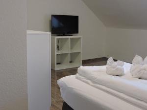 Habitación con 2 camas con almohadas blancas y TV. en Monteurhaus Scheidter 40, en Saarbrücken