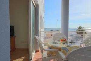 een tafel en stoelen met uitzicht op de oceaan bij 020 - Senya Gran Playa 001 - comfortHOLIDAYS in Santa Pola