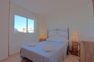 1 dormitorio con 1 cama con 2 toallas en 020 - Senya Gran Playa 001 - comfortHOLIDAYS, en Santa Pola