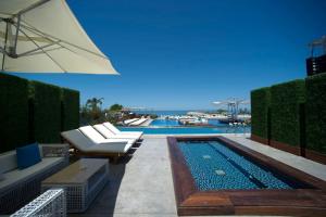 una piscina con tumbonas y sombrilla en Veer Luxury Boutique Hotel & Beach Club en Jounieh