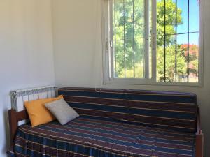 un banc dans une chambre avec fenêtre dans l'établissement Apartamento con excelente ubicación y vista al Rio, à Colonia del Sacramento