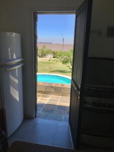 - une porte menant à une chambre avec vue sur la piscine dans l'établissement Apartamento con excelente ubicación y vista al Rio, à Colonia del Sacramento