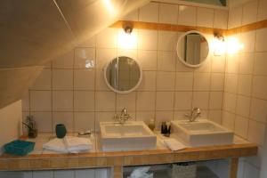 a bathroom with two sinks and two mirrors at Au Relais de Chaussy in Chaussy +24 photos