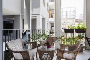 einen Balkon mit Korbstühlen und einem Tisch in der Unterkunft Porto Fluviale House in Rom