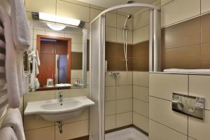ein Bad mit einem Waschbecken und einer Dusche in der Unterkunft Hotel City Inn in Budapest