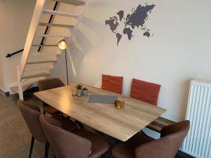 een tafel met stoelen en een bureau met een laptop erop bij Vakantieverblijf 'Mara Cinco' met ruim terras in Oostende in Oostende