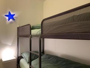 een slaapkamer met 2 stapelbedden en een blauwe ster aan de muur bij Vakantieverblijf 'Mara Cinco' met ruim terras in Oostende in Oostende