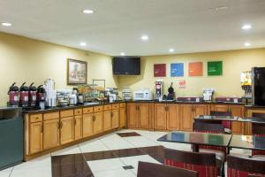 a restaurant with wooden cabinets and tables and a television at Comfort Inn Columbia -Bush River in Columbia