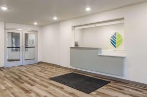 una stanza vuota con pareti bianche e pavimenti in legno di WoodSpring Suites Tacoma - Lakewood a Lakewood