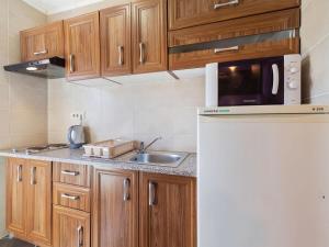 a kitchen with wooden cabinets and a sink and a microwave at Top view in Opatija +4 photos