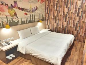 a bedroom with a large bed with a painting on the wall at Sanduo Hotel in Kaohsiung +44 photos