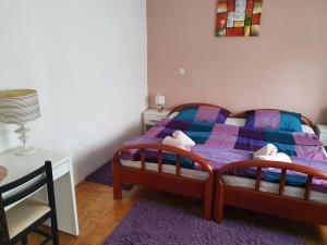 a bedroom with a bed and a table and a chair at Apartmani Lovro in Ogulin