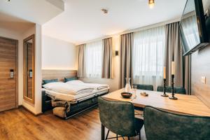 pokój hotelowy z łóżkiem, stołem i krzesłami w obiekcie FOXY Obertauern w mieście Obertauern