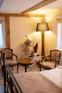 a bedroom with a bed and two chairs and a table at Raxti in Kuldīga