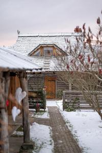 una casa está cubierta de nieve con una valla en Raxti en Kuldīga