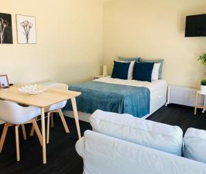 Cette chambre comprend un lit, une table et un canapé. dans l'établissement Apartments Business Flats Brussels Airport, à Zaventem