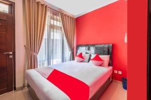 a red bedroom with a large bed with red pillows at OYO Collection O 1032 Rahayu Residence Syariah in Cirebon
