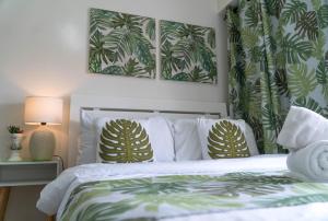 um quarto com uma cama com almofadas verdes e brancas em An Oasis in Tagaytay em Tagaytay