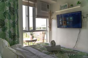 a bedroom with a bed and a large window at An Oasis in Tagaytay in Tagaytay