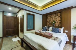 a bedroom with a large bed with a table on it at Wannamas Chiangmai Boutique House -SHA Extra Plus in Chiang Mai