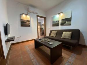 Una sala de estar con un sofá y una mesa de café. en Casa Familiar cerca de la playa piscina compartida, en Cádiz
