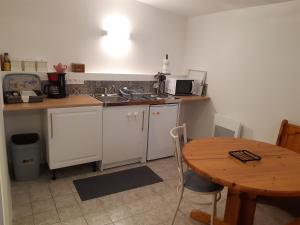 uma cozinha com uma mesa, um lavatório e uma mesa em Le Cezembre gîte la Taniere em Moidrey