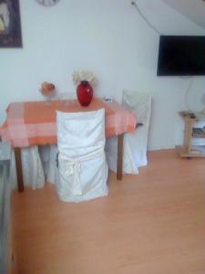 a table and chairs with a red vase on it at Apartment Damir in Opatija