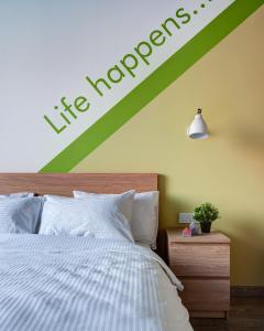 a bedroom with a bed with a sign on the wall at Roomy Hostel in Yekaterinburg