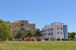 a group of buildings and palm trees in a field at Campitur in Campomarino