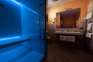 La salle de bains est pourvue d'une porte bleue et d'un lavabo. dans l'établissement Hotel Foresta, à Moena