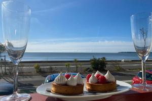 two deserts with strawberries and whipped cream on a table with wine glasses at Venice Beach LA BAULE appartement face à la mer! in La Baule