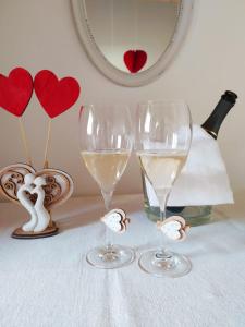 two wine glasses sitting on top of a table with hearts at B&B Dolomitincanto in Cesiomaggiore