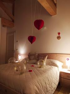 a bedroom with hearts hanging on the wall and a bed at B&B Dolomitincanto in Cesiomaggiore