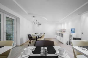 a living room with a table and chairs and a kitchen at Hévízi Tópark Panzió II. in Hévíz