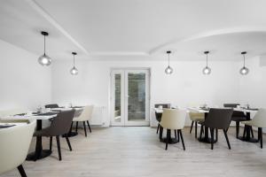 a dining room with tables and chairs and a window at Hévízi Tópark Panzió II. in Hévíz