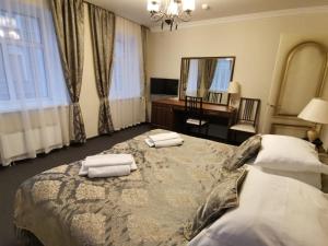 a bedroom with a large bed with two towels on it at History Hotel in Vologda