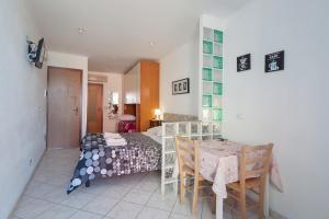 una camera con letto, tavolo e sedie di Giovanna dei Rocca - appartamento sul mare a Riomaggiore