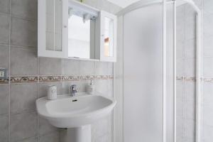 a bathroom with a sink and a mirror and a shower at Giovanna dei Rocca - appartamento sul mare in Riomaggiore
