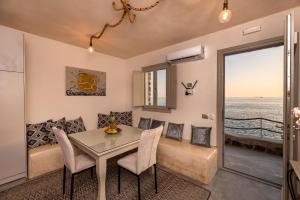 a dining room and living room with a table and chairs at BLACK BAY CAVES SUITES in Akrotiri