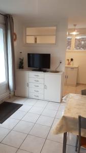 a living room with a tv on a white dresser at Le Crotoy Plage Baie de somme Appt l'Aigrette in Le Crotoy