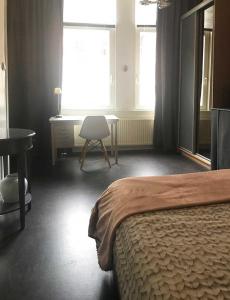 a bedroom with a bed and a desk and a window at Appartement Rotterdam Noord in Rotterdam