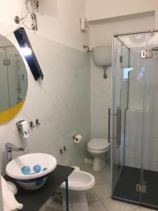 a bathroom with a shower and a toilet and a sink at Hotel Pelaghea in Linosa