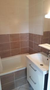 een badkamer met een bad, een wastafel en een bad bij Chez Fifille appartement dans Honfleur parking privé in Honfleur