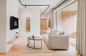 una sala de estar con un sofá y una mesa en das bleibt Alpine Suites, en Schladming